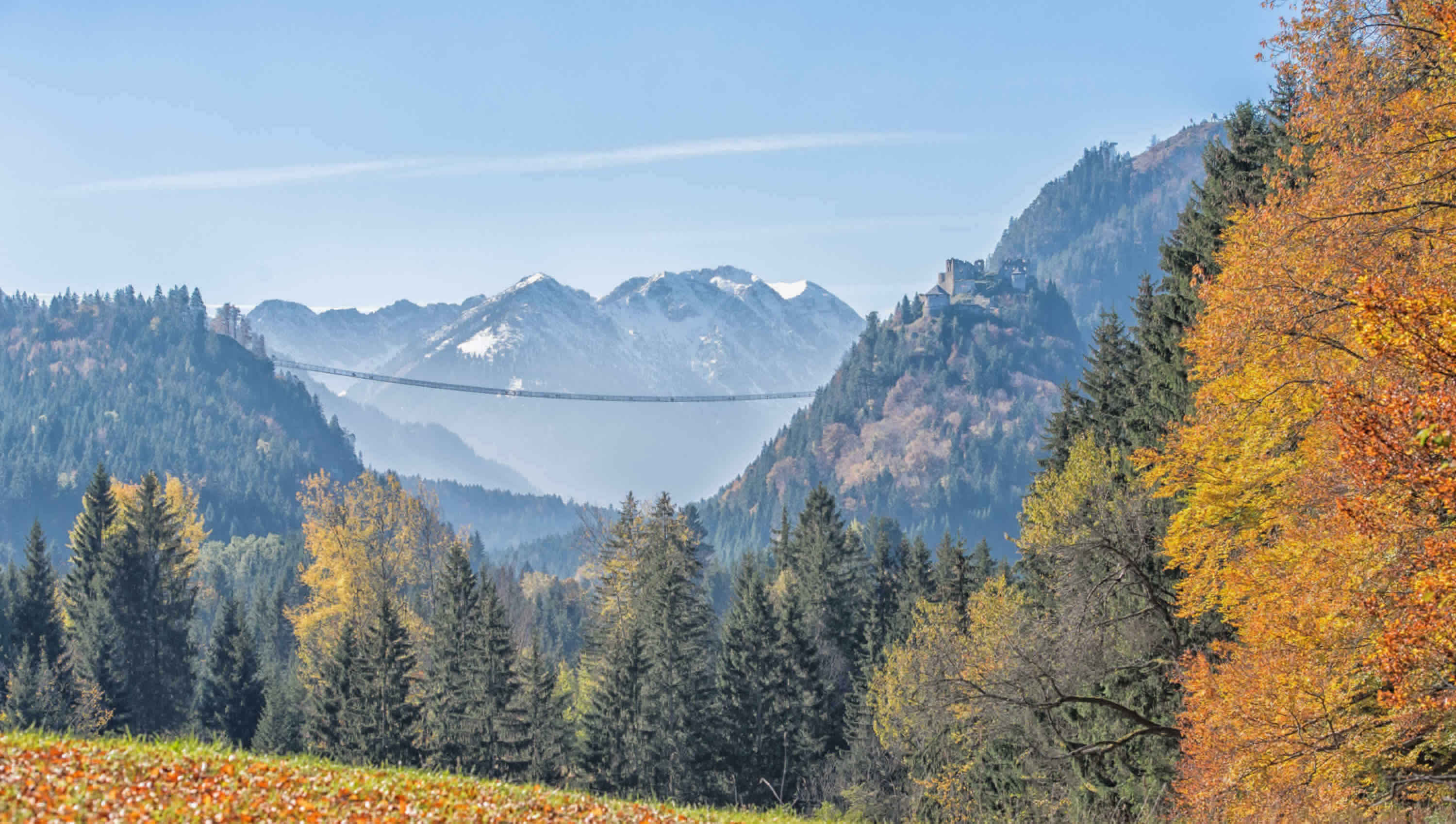 highline179 Herbstpanorama – weitläufiger Blick auf die Hängebrücke über dem Lechtal mit verschneiten Gipfeln